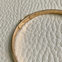 A solid gold hinged bangle made in 1978 in Sävsjö, Sweden. Solid bangles like this are rare finds! What I love about them is that they cannot dent - this style is a solid bar of gold!  This amazing vintage Scandinavian 18k gold bangle is oval shaped with a femme half-round cross section. Interior of the oval measures 2 inches (50mm) x 2.4 inches (60mm) and opens with a well working and beautiful hinge. She weighs an excellent 18.2g 