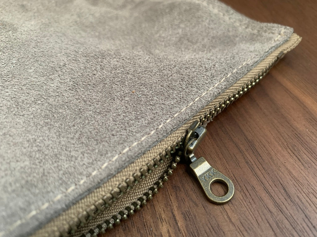 Simple leather zipper pouch to keep you organized.  Bovine suede.  Measures 10” x 7”  Metal zip with donut pull. Attach a wrist strap to zipper tab to make this into a clutch.